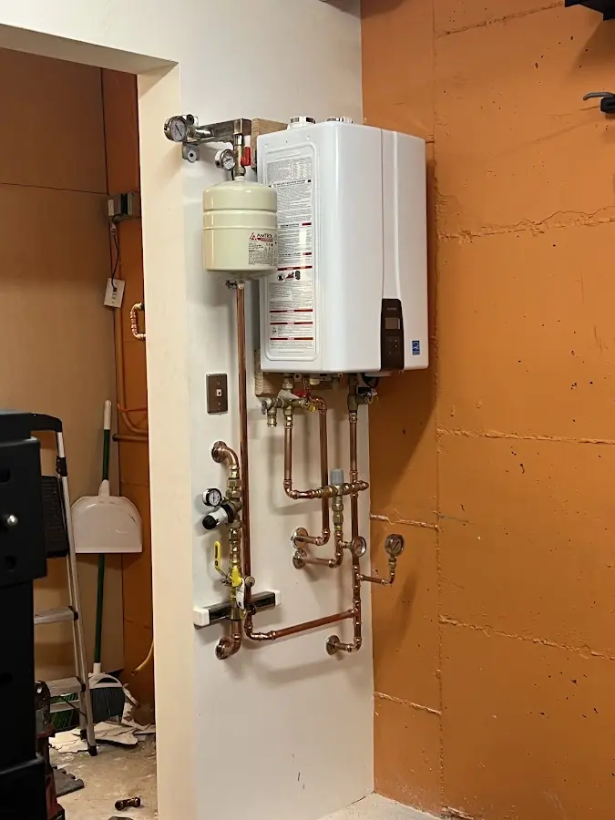 Plumbing technician inspecting water heater connections in Jacksboro
